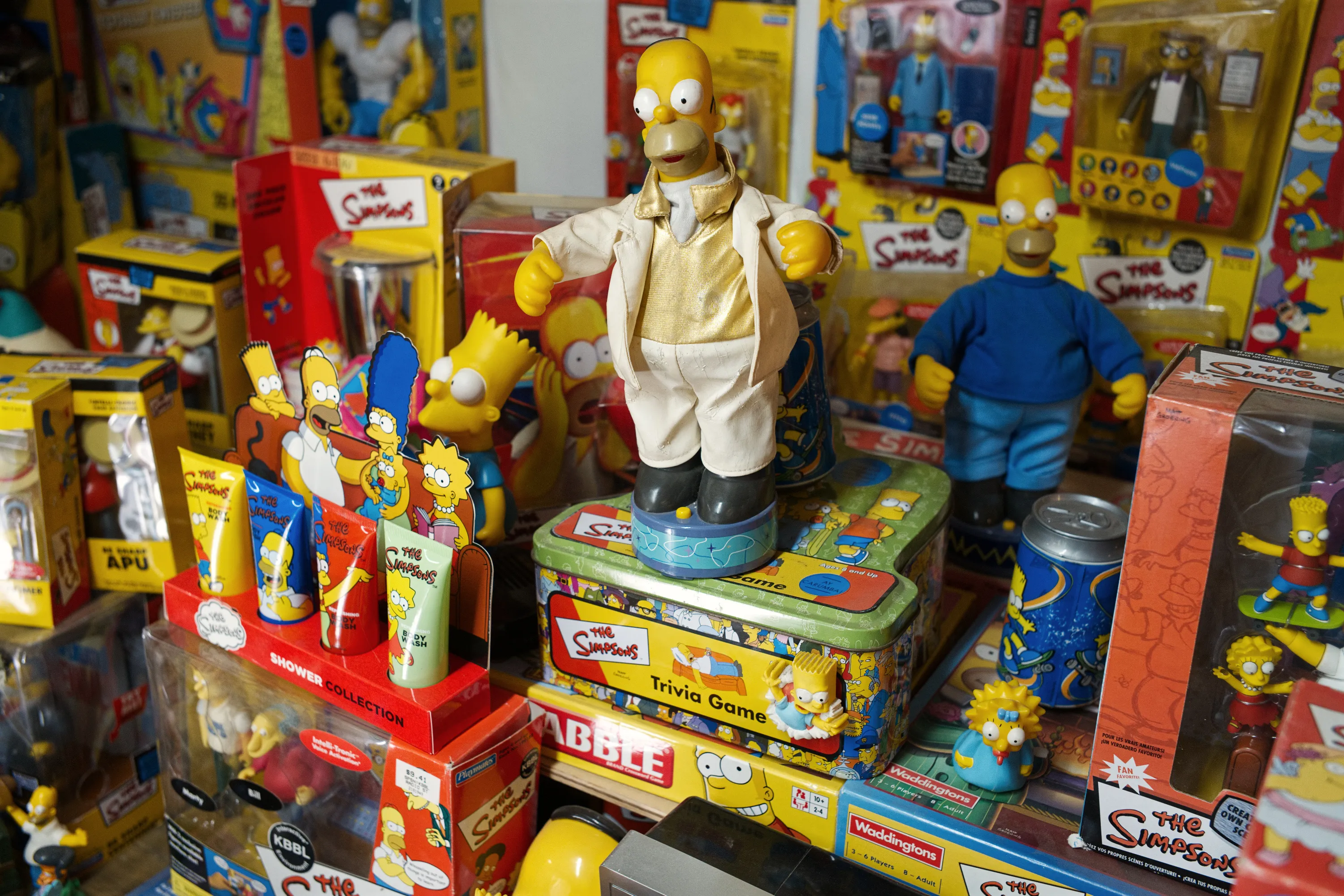 A close view of Simpsons merchandise: figures, board games, and boxed collectables densely arranged on shelves