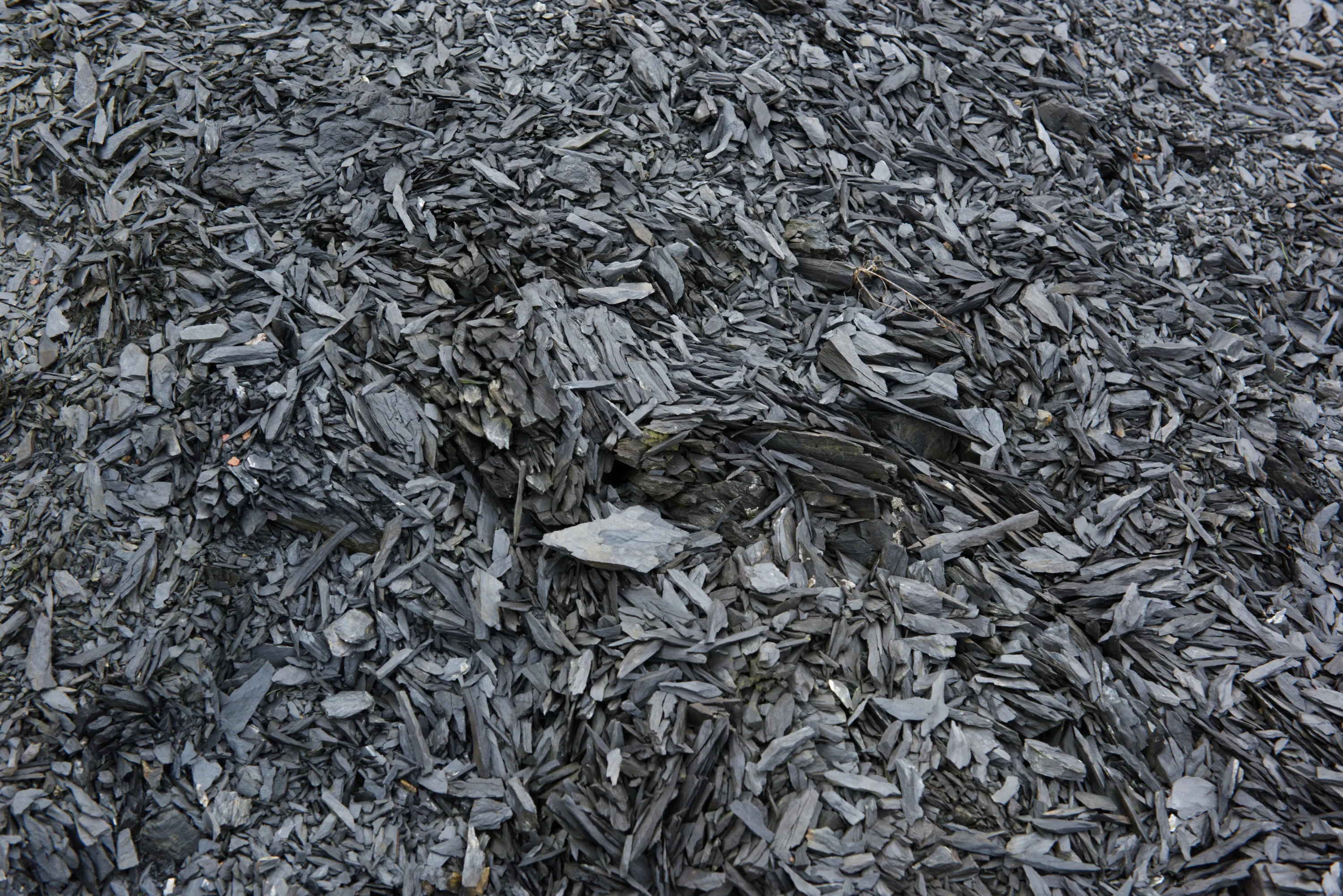 Aerial-view close-up of crushed dark shale fragments covering the ground